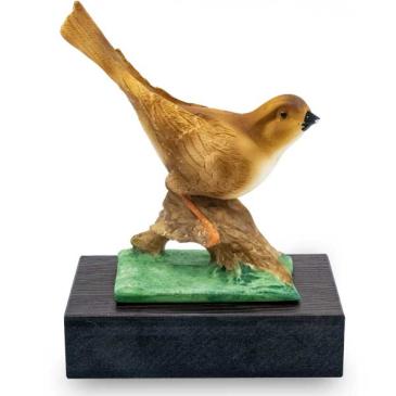 Trofeo de resina de pajaro marron sobre cesped