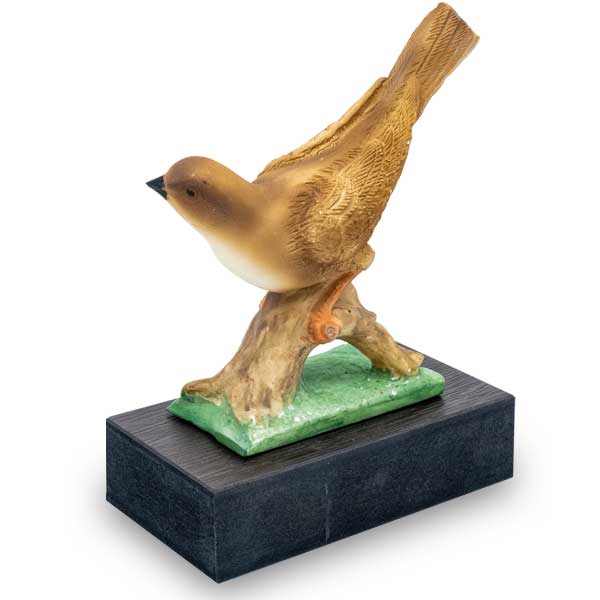 Trofeo de resina de pajaro marron sobre cesped
